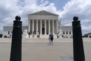 Visitors pose for photographs outside the U.S. Supreme Court.