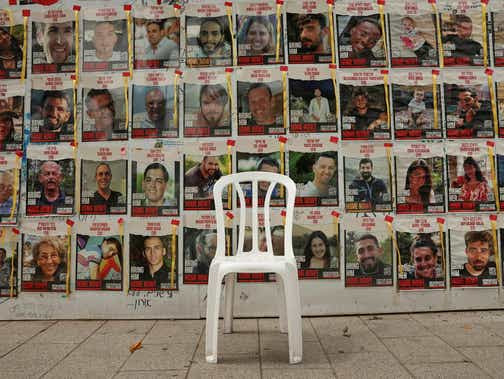Une chaise est laissée devant des affiches avec des photos d'otages kidnappés lors de l'attaque meurtrière du 7 octobre contre Israël par le groupe islamiste palestinien Hamas, dans le contexte du conflit en cours à Gaza entre Israël et le Hamas, à Tel Aviv, Israël, le 26 avril. 2024. REUTERS/Shannon Stapleton