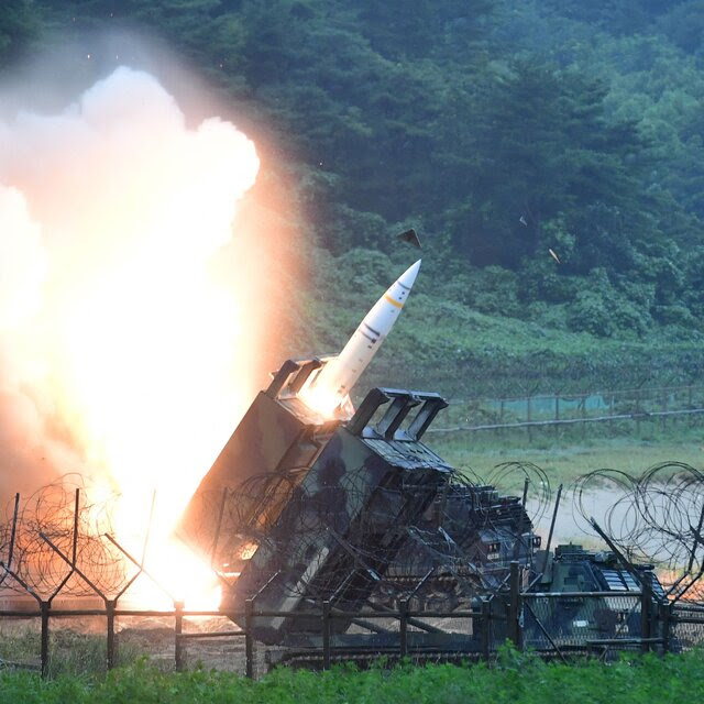A missile being fired from a missile launcher, with a cloud of fire.