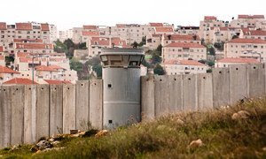 El Muro de Separación en el Territorio Palestino Ocupado y detrás un asentamiento israelí.