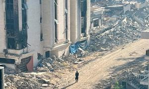 Una persona camina entre las ruinas de un barrio de Gaza.