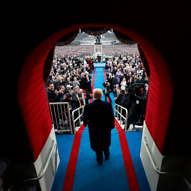 Donald Trump seen from behind walking out to the podium at his inauguration.