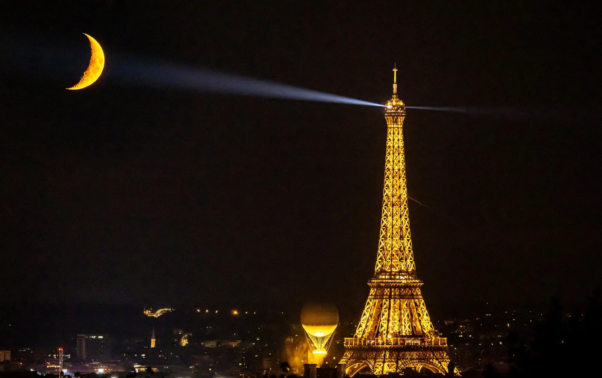 The moon is pictured with the Olympic cauldron and the Eiffel Tower 