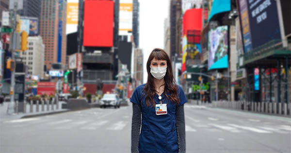 healthcare worker standing in Times Square with a mask on