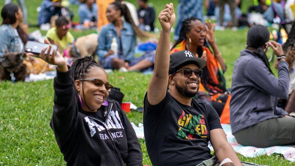 Two festival-goers hanging out at the park during Good Vibes in the Park. 