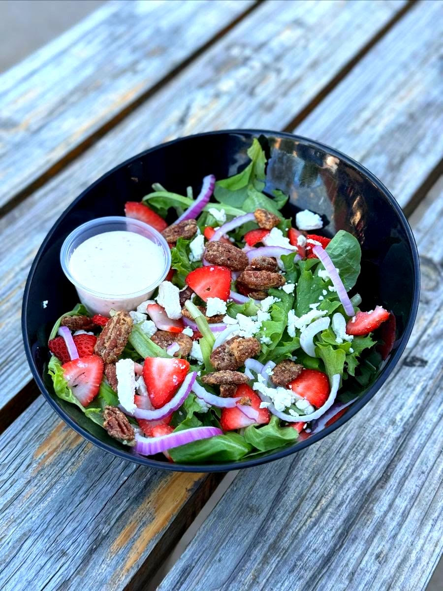 A picture of Strawberry fields salad on a bowl. 