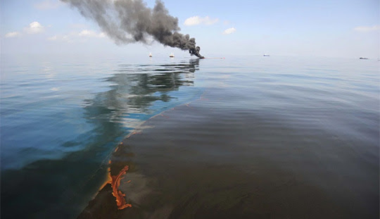 Dark clouds of smoke and fire emerge as oil burns during a controlled fire in the Gulf of Mexico in the aftermath of the Deepwater Horizon oil spill disaster. (Mass Communication Specialist 2nd Class Justin Stumberg / U.S. Navy)