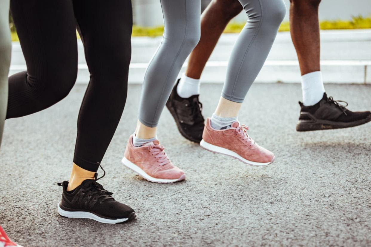 three pairs of feet in sneakers on street