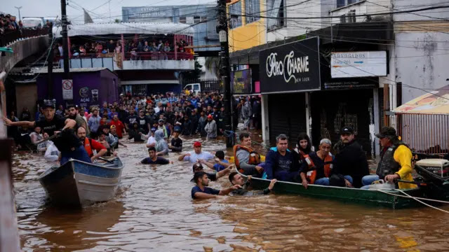 Pessoas sendo resgatadas com barcos durante as inundações no Rio Grande do Sul em maio de 2024