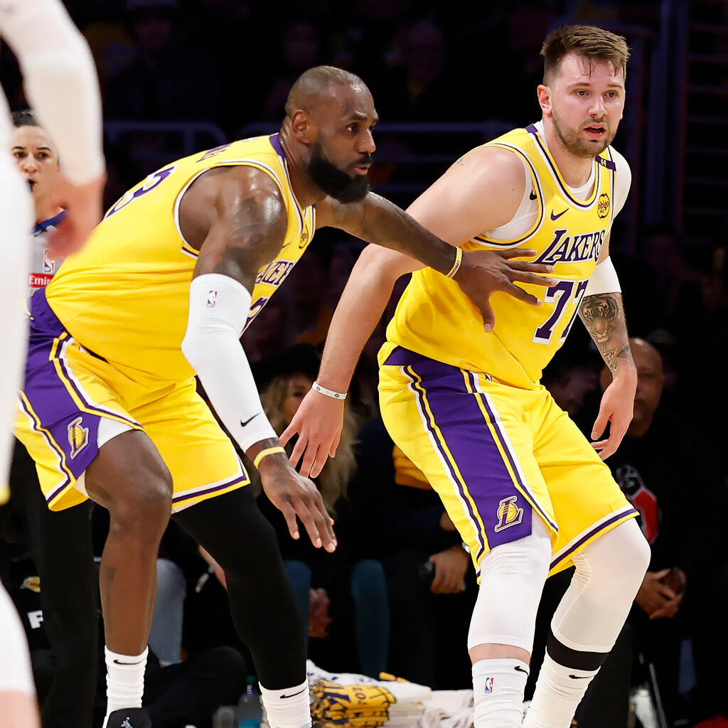 LeBron James and Luka Doncic, in yellow Lakers jerseys, play defense side-by-side against the Utah Jazz.