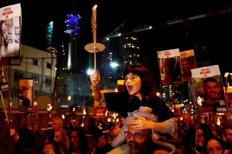 A child holds a candle during a torch march for Israeli hostages, who are being held in the Gaza Strip after they were seized by Hamas gunmen on October 7, as the country observes the Jewish festival Hanukkah, amid the ongoing conflict between Israel and the Palestinian Islamist group Hamas, in Tel Aviv, Israel December 7, 2023. REUTERS/Clodagh Kilcoyne TPX IMAGES OF THE DAY