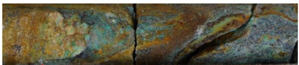 a) Oxide.78.8m depth. Hematite-goethite-jarosite weathering with malachite.40.0m @ 0.39% Cu