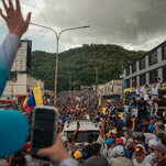 A street filled with people at a political rally with María Corina Machado and Edmundo González.