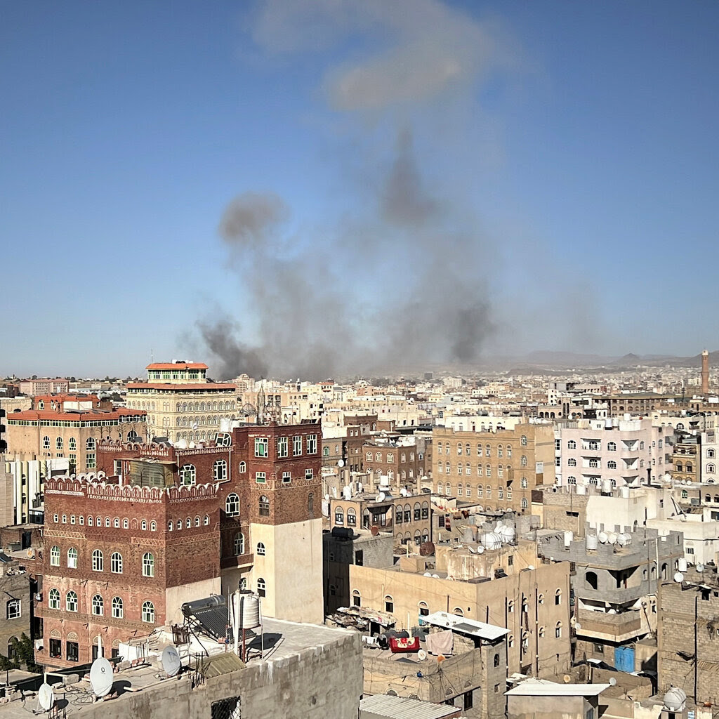 Smoke rises above a crowded city. 