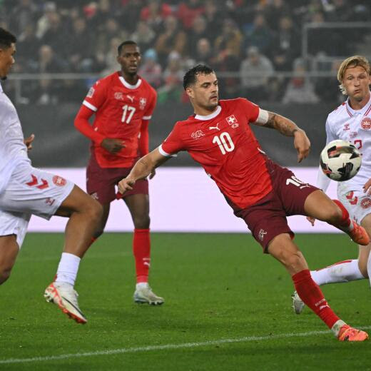 Switzerland's midfielder #10 Granit Xhaka (CR) and Denmark's defender #18 Alexander Bah (L) compete for the ball during the UEFA Nations League, League A, Group A4 football match between Switzerland and Denmark at The Kybunpark in St Gallen on October 15, 2024. (Photo by Fabrice COFFRINI / AFP)