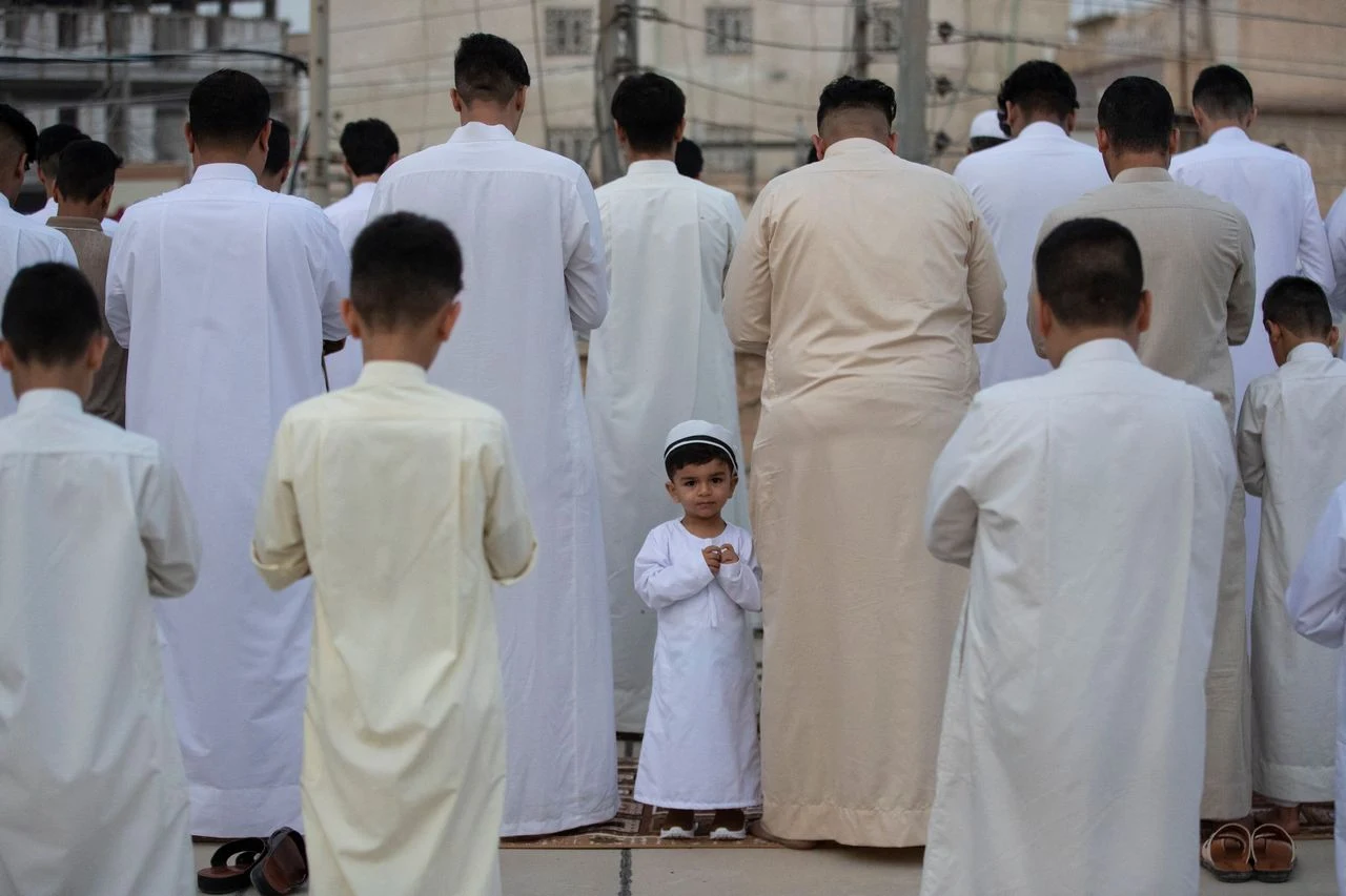 A child stands amid Eid worshippers in Iraq. (Hussein Faleh/AFP via Getty Images)