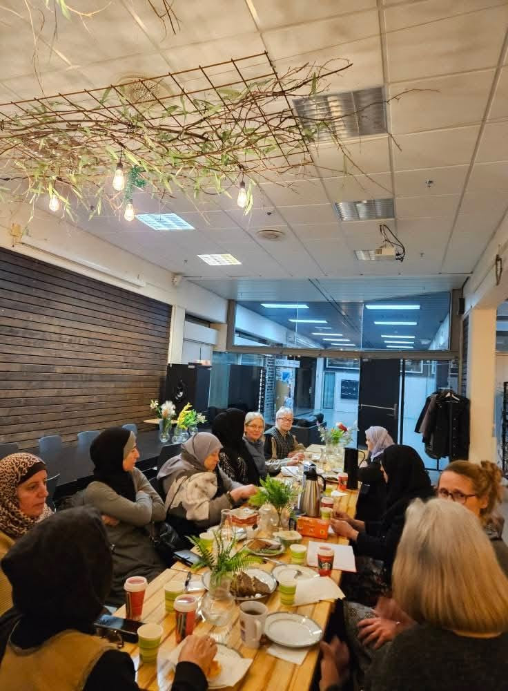 a group of people sitting around a long table in a restaurant