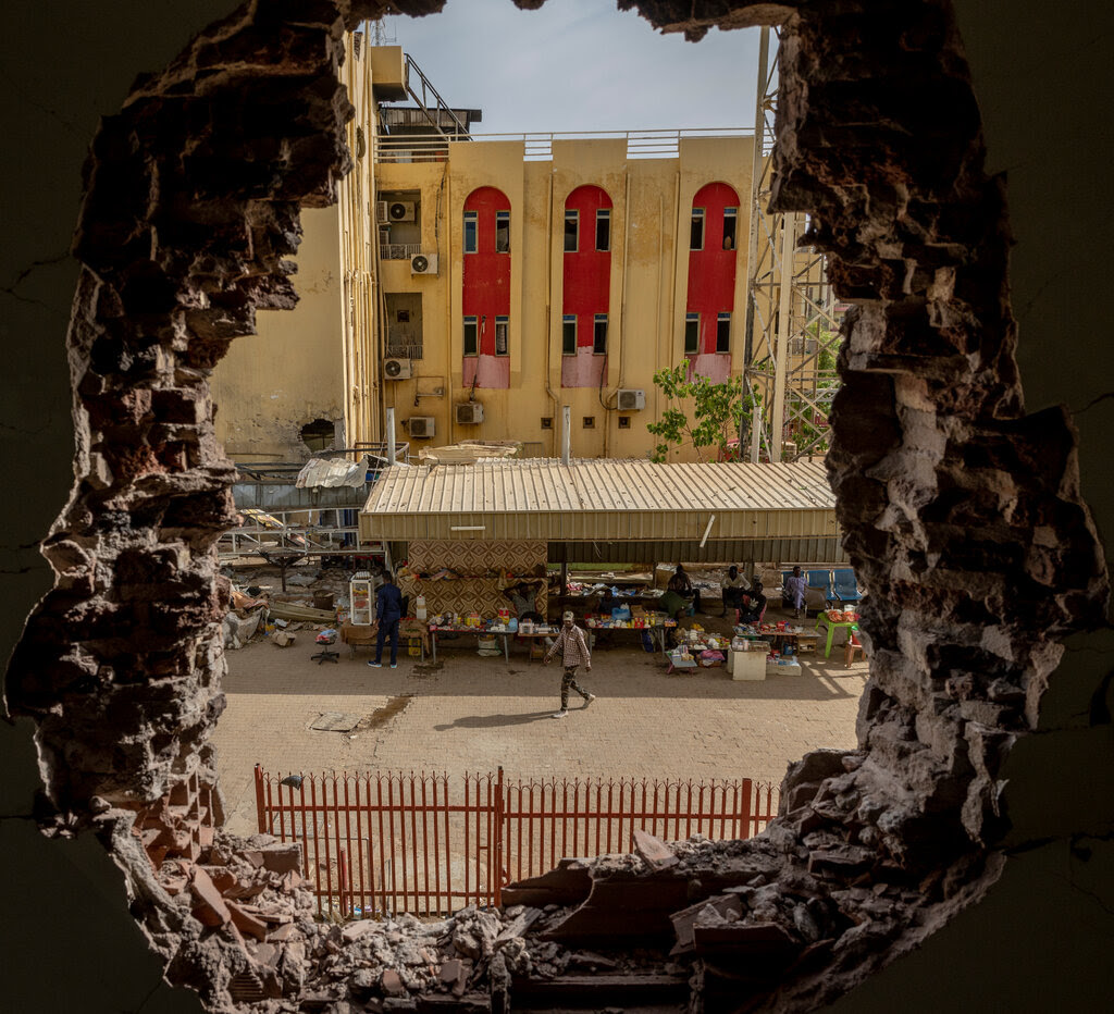 Uma imagem de uma rua no Sudão tirada através de um buraco em um prédio.