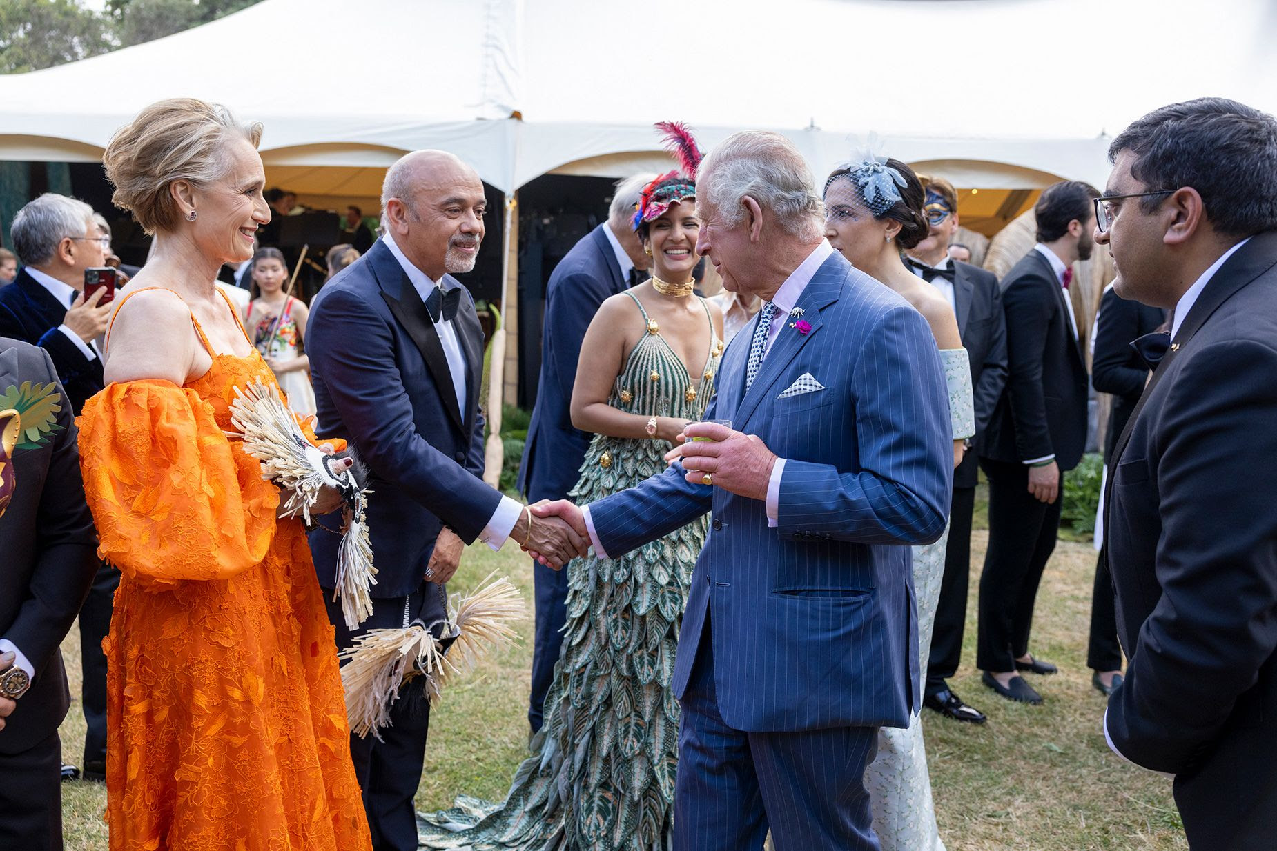 El rey Carlos III habla con Christian Louboutin y la actriz Kristin Scott Thomas en una fiesta en el jardín en 2023 en Londres.Heathcliff O'Malley/WPA Pool/Getty Images
