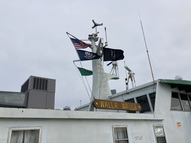 United States, U.S. Navy, POW/MIA and Washington state flags flying atop a ferry