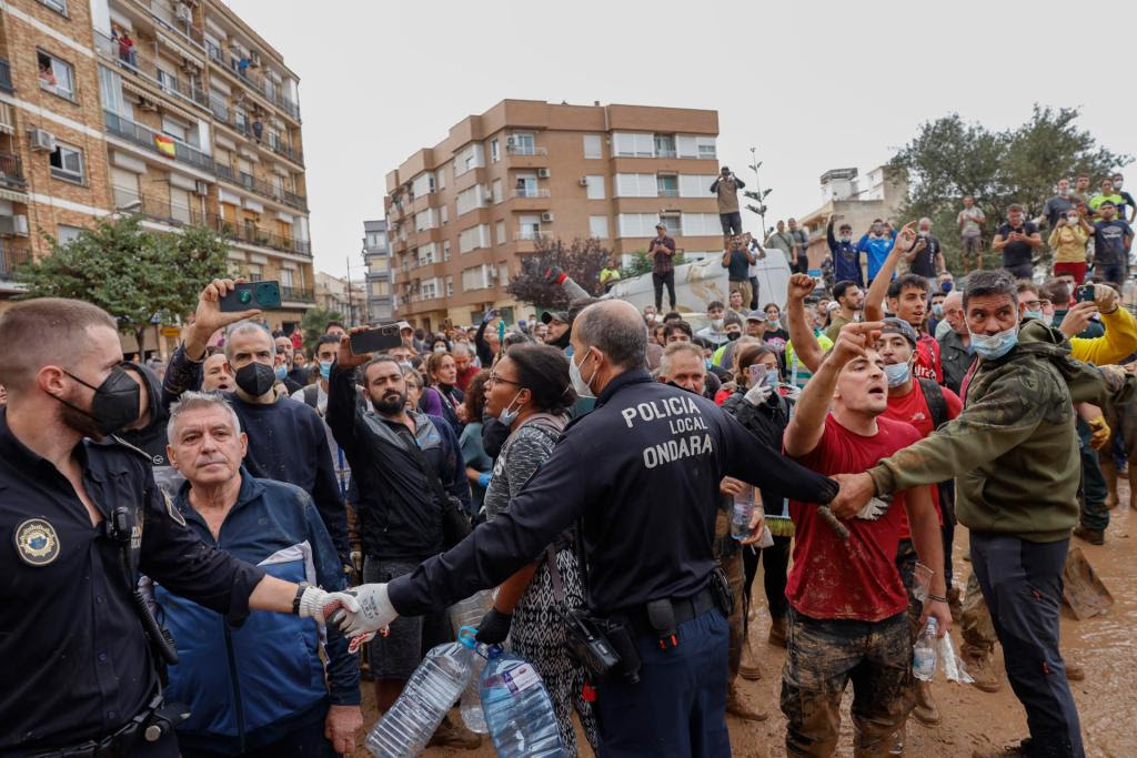 PAIPORTA (VALENCIA), 03/11/2024.- Vecinos de Paiporta durante la visita del rey Felipe y la reina Letizia, el presidente del Gobierno Pedro Sánchez y el presidente autonómico Carlos Mazón a Paiporta este domingo. Gritos de 'fuera', así como lanzamiento de barro, están recibiendo a la comitiva de los reyes de España, Pedro Sánchez, y Carlos Mazón, a su llegada al centro de Paiporta. Numerosas personas indignadas han recibido con insultos a la comitiva y se han encarado con ella, mientras que tanto el rey como la reina ha intentado mediar con jóvenes que se les han acercado. Foto: EFE/ Ana Escobar