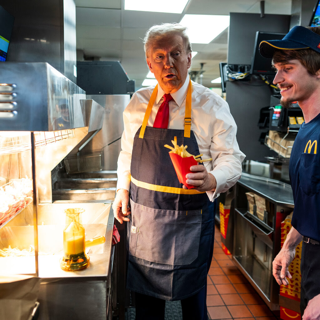 Donald Trump holding fries in a McDonalds apron. 