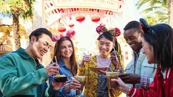 The Lunar New Year Festival. Friends enjoying food and beverages, then taking a group photo with Mickey Mouse and Minnie Mouse.