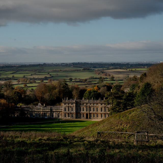 A grand house in a rolling landscape.