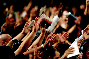 Many people have their hands raised in worship.
