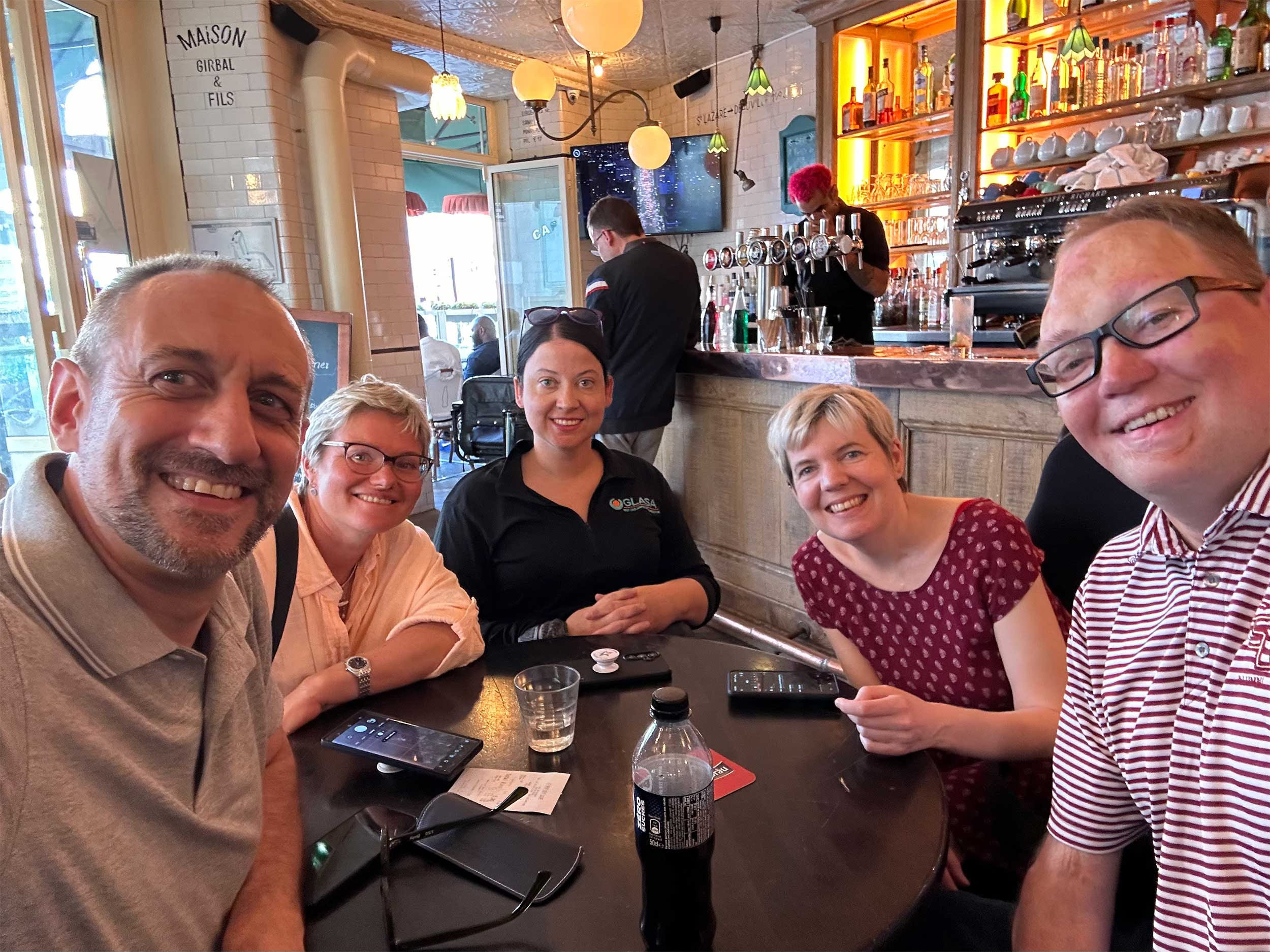 Selfie of John with wheelchair users sitting around a table in a cafe.