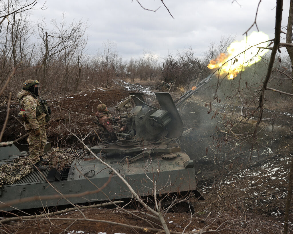 A Ukrainian antiaircraft tank in a wooded area fires into the sky.