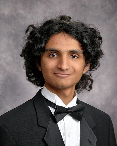 a senior style photo of Omkar Subramanian, he is wearing a black tuxedo jacket, black bowtie and white shirt