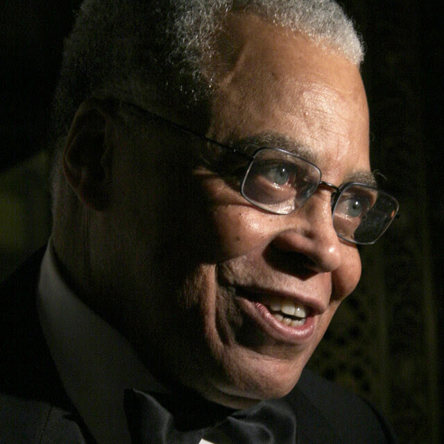 James Earl Jones smiles while looking away from the camera. 