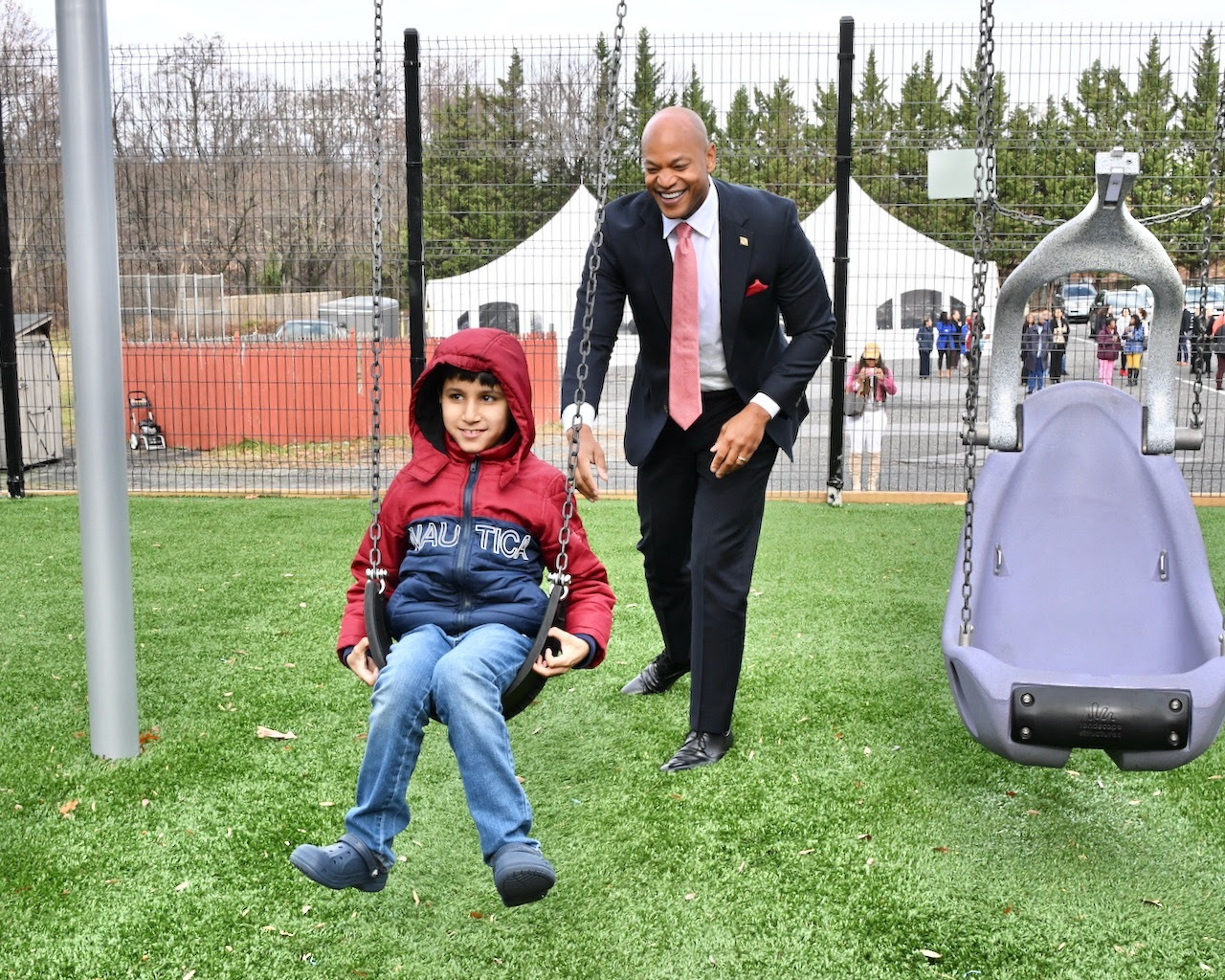 Governor Moore pushes student on a swing at The Children's Guild Transformation Academy's Adaptive Playground