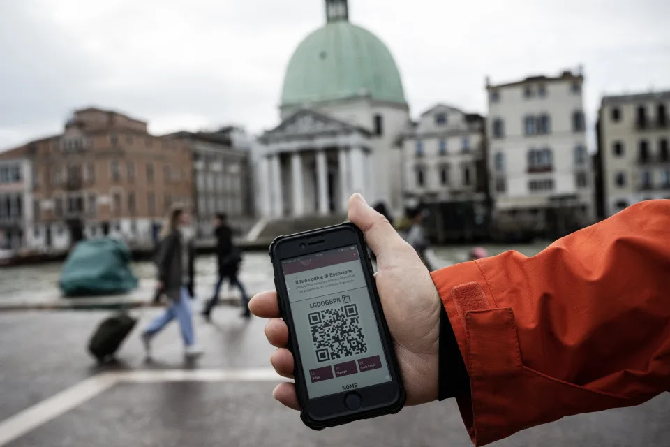 Esta fotografía tomada el 25 de abril de 2024 muestra un código QR para acceder a la ciudad que se muestra en un teléfono inteligente frente a la estación de trenes de Santa Lucía mientras esperan para comprar boletos, ya que los visitantes que ingresan al sitio declarado Patrimonio de la Humanidad por la UNESCO por un día deben comprar un boleto de cinco euros ($ 5.3), en Venecia. Venecia lanzó un nuevo plan para cobrar a los excursionistas por ingresar a la histórica ciudad italiana, una primicia mundial destinada a aliviar la presión del turismo de masas, pero muchos residentes se oponen, en Venecia, el 25 de abril de 2024. (Foto de MARCO BERTORELLO/AFP vía Getty Images)