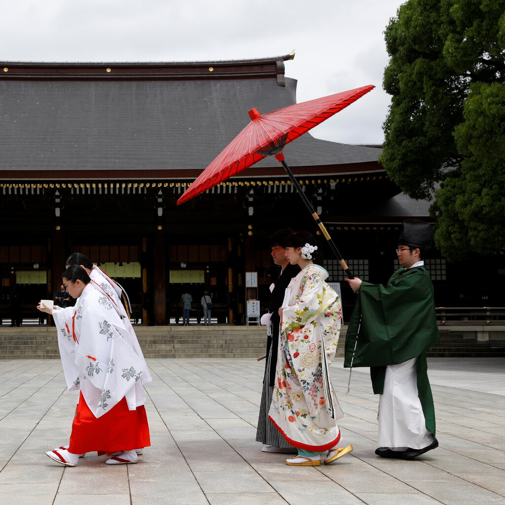 Four people in traditional Japanese dress at a Shinto shrine in Tokyo.