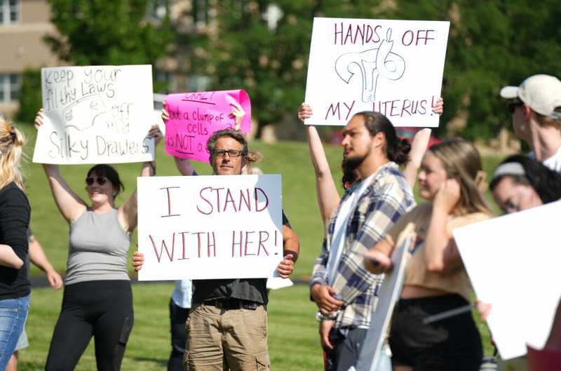 Protesters hold signs at a June 24, 2022, rally in Kansas City, Missouri, after the U.S. Supreme Court overturned Roe v. Wade. Kansas has become one of few states in the region to offer abortion services, leading to a surge in out-of-state patients. (Margaret Mellott/Kansas Reflector)