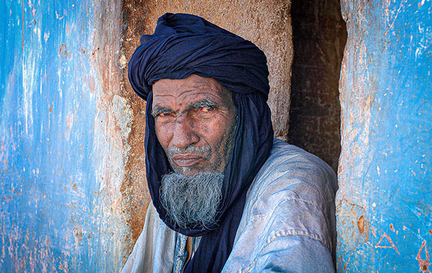 Man sitting in front a blue building in Libya