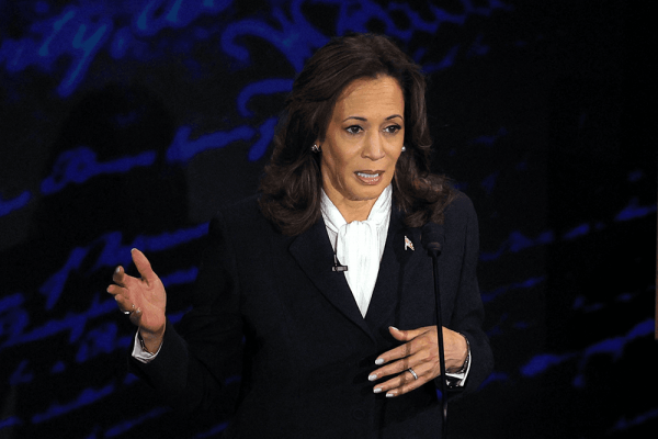 Vice president, Kamala Harris, speaking on debate stage, gesturing with hands. 