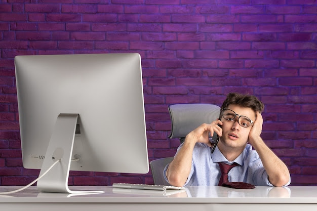 Front view office worker behind office desk talking