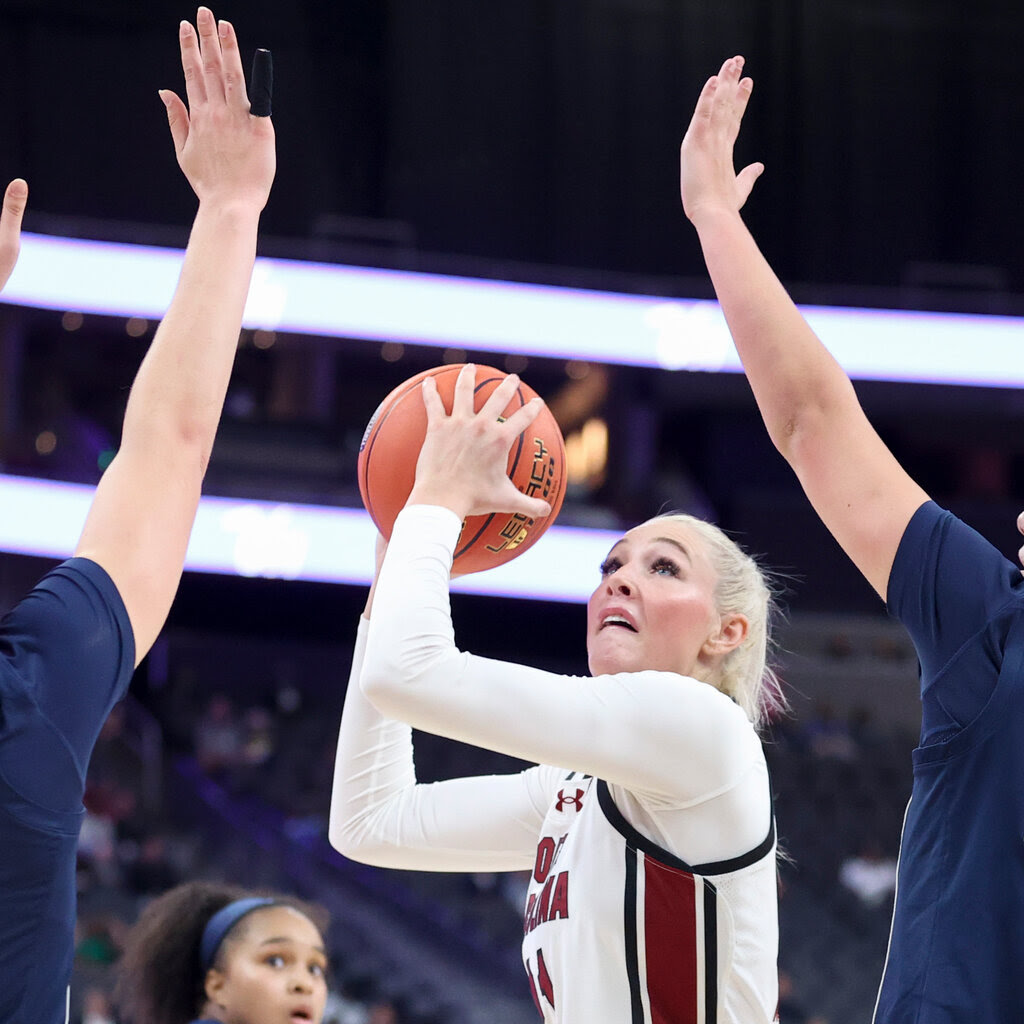 Chloe Kitts shoots a basketball over defenders.