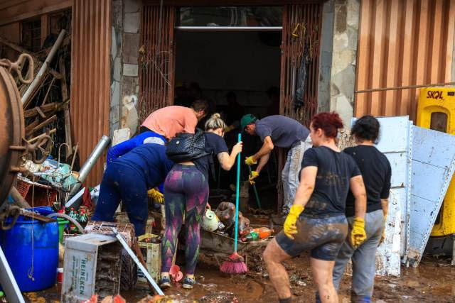 Moradores limpam ruas enlameadas de Muçum