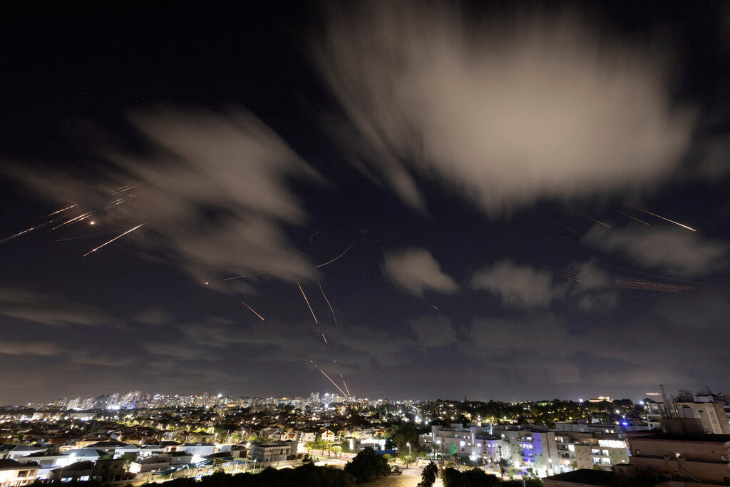 Lights from a city and streaks in the dark sky.