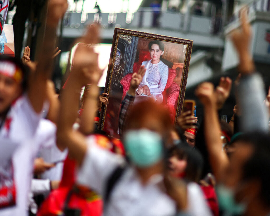 Protesters hold a framed image of Aung San Suu Kyi. 