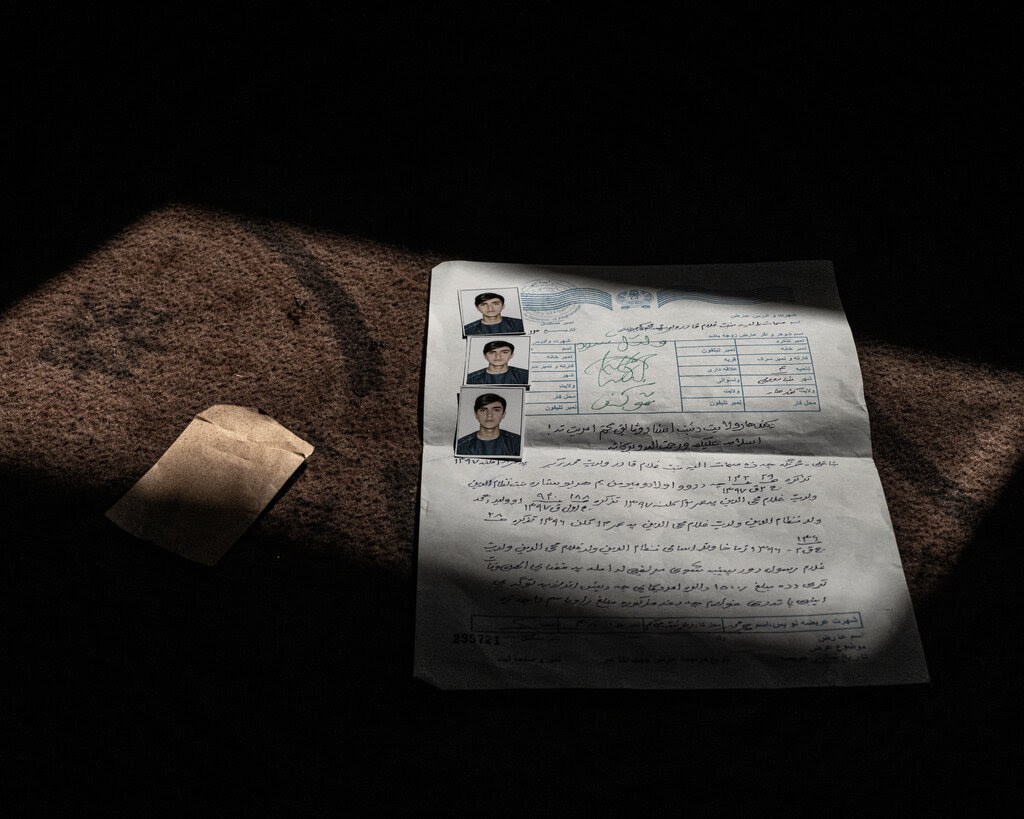 A government document and three passport photos of a young man.