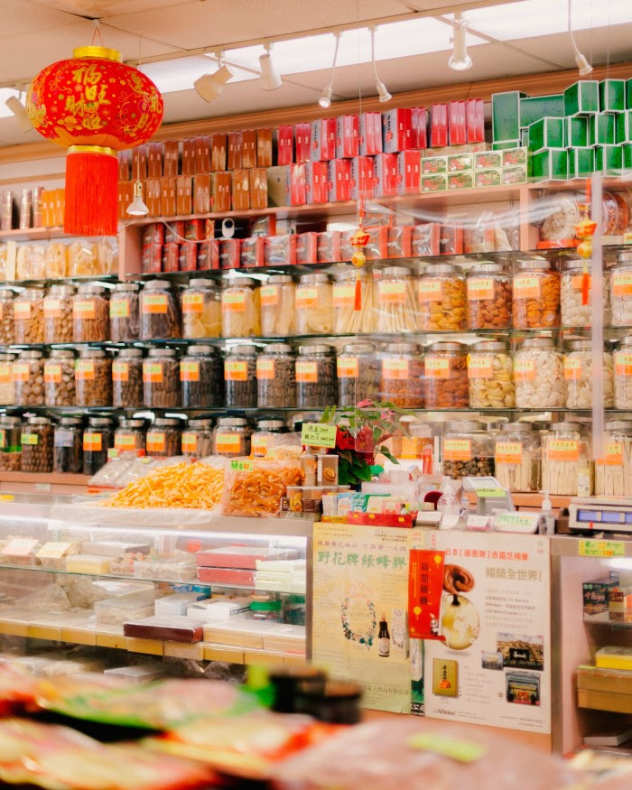  Shelves and counters stacked with ingredients in the traditional Chinese herbal shop that the tour stops at