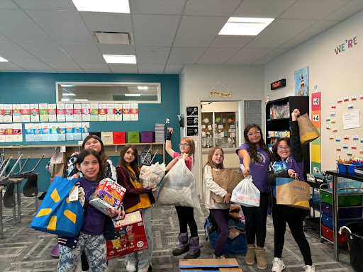 Joyful students showing off their shopping bags in a vibrant classroom environment.