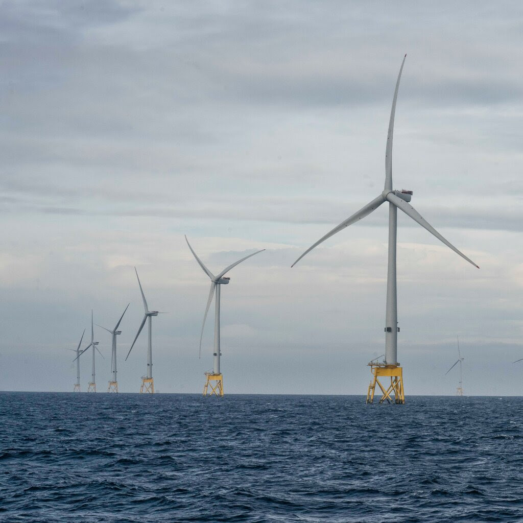 Offshore wind turbines standing in the ocean off Scotland.