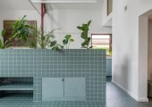 Para marcar la transición entre la cocina y el comedor se incorporó una jardinera tropical de azulejos azul claro, aportando un toque de frescura y vitalidad al ambiente.
