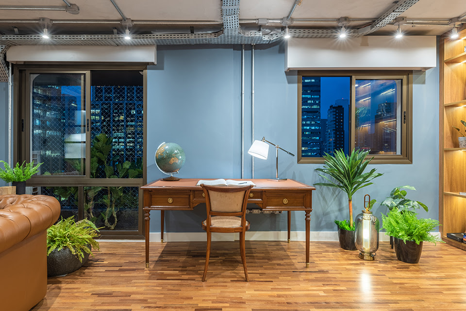 Integrado com a sala de TV, o arquiteto Pietro Terlizzi definiu a mesa do home office em um ponto muito bem iluminado | Foto: Guilherme Pucci